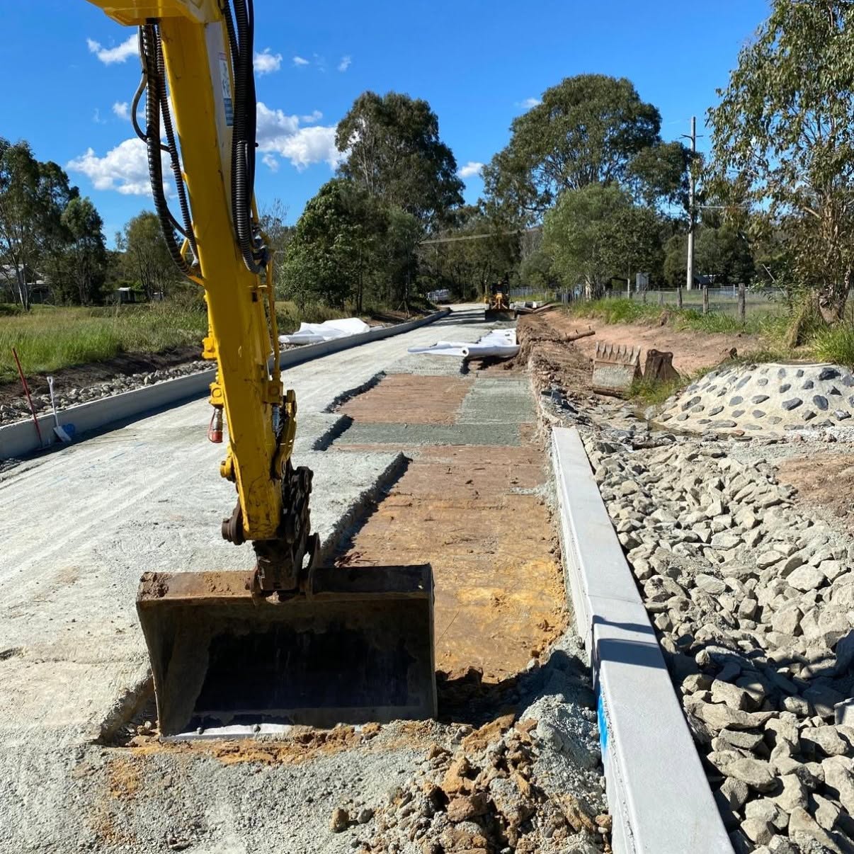Excavator beside gabion wall
